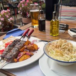 Dinner in Novi Sad — grilled meat, potatoes, cabbage salad and a very welcome beer.