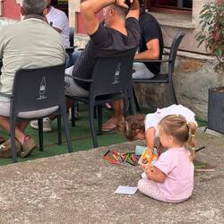 Spielende Kinder, während die Erwachsenen essen und sich unterhalten ...