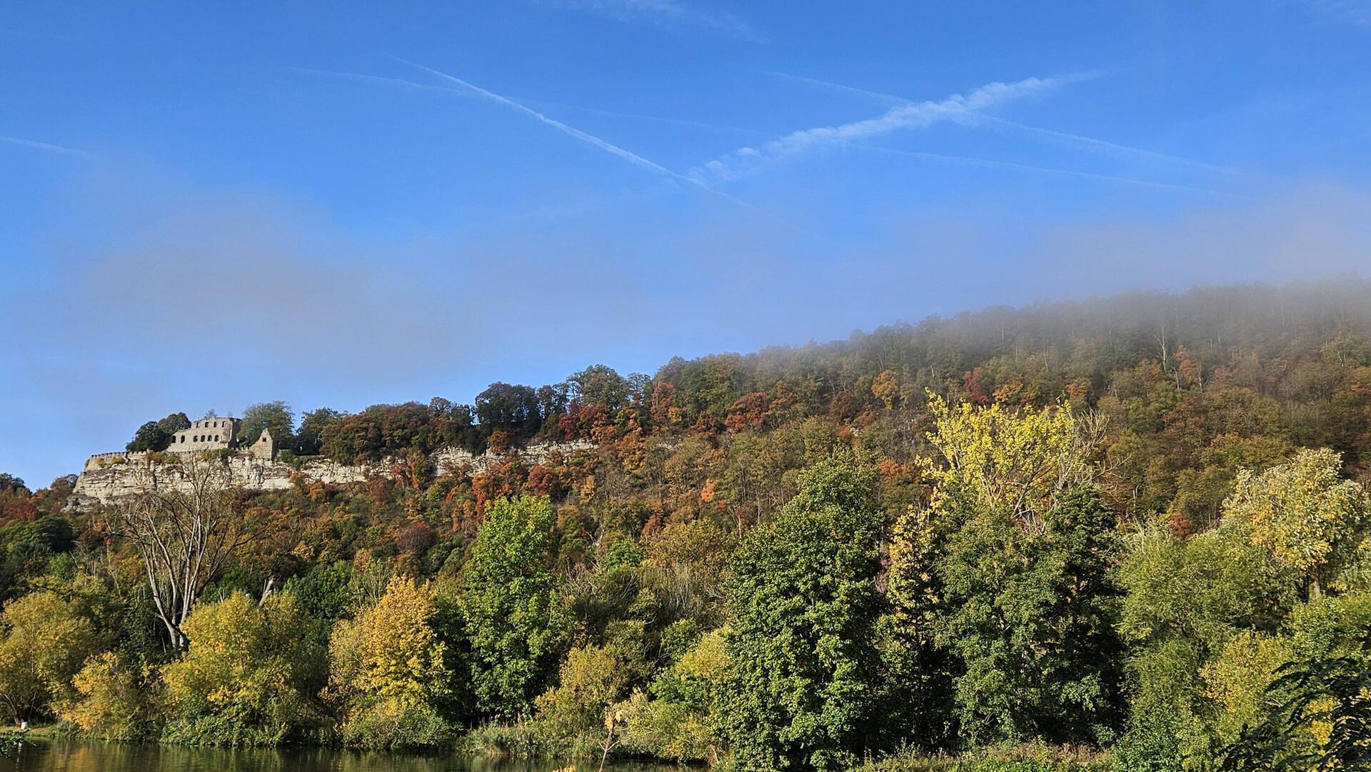 Ruine Karlsburg im aufsteigenden Morgennebel überm Main