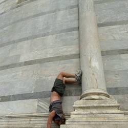 De opdracht om een handstand te maken tegen een Romeins pilaar