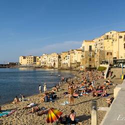 The main beach is busy even in the early evening hours — Cefalù, Sicily.