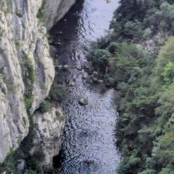 Da unten sieht man mehrere Leute mit gelben Helmen die Canyoning machen.