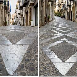 Cobblestone street; the stone used in the pattern has embedded fossils — Cefalù, Sicily.