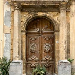 Ancient wooden door of the Town Hall (Palazzo Municipale) framed by classical columns.