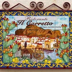 A colorful ceramic sign at a restaurant in Old Town — Cefalù, Sicily.