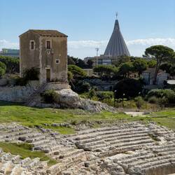 Glimpse of the cone-shaped roof of Basilica Santuario Madonna delle Lacrime in the distance.